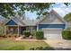 Charming home featuring stone accents, blue siding, a well-manicured lawn and an attached two-car garage at 3846 Bent Creek Sw Dr # 58, Concord, NC 28027