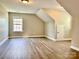 Spacious attic with wood-look flooring and a large window at 6008 Grassy Knoll Cir, Matthews, NC 28104