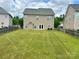 A fenced backyard featuring a lush lawn and the rear elevation of the home at 6008 Grassy Knoll Cir, Matthews, NC 28104
