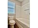 Bright bathroom featuring a bathtub and toilet near a window at 6008 Grassy Knoll Cir, Matthews, NC 28104