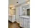 Modern bathroom with dual vanities, wood flooring, and contemporary fixtures at 6008 Grassy Knoll Cir, Matthews, NC 28104