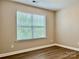 Bright bedroom with a large window, neutral walls, and wood-look flooring at 6008 Grassy Knoll Cir, Matthews, NC 28104