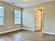 Bright, empty bedroom with wood-look flooring and a large window at 6008 Grassy Knoll Cir, Matthews, NC 28104