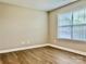 Bright, empty bedroom with wood-look flooring and a large window at 6008 Grassy Knoll Cir, Matthews, NC 28104