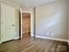 Open bedroom with wood-look flooring and a white door at 6008 Grassy Knoll Cir, Matthews, NC 28104