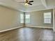 This bedroom has a tray ceiling, ceiling fan and multiple windows for natural light and backyard views at 6008 Grassy Knoll Cir, Matthews, NC 28104