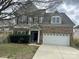 Charming two-story home featuring a brick facade, an attached two-car garage, and a cozy front porch at 6008 Grassy Knoll Cir, Matthews, NC 28104