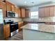 Modern kitchen with stainless steel appliances, granite countertops, and a central island at 6008 Grassy Knoll Cir, Matthews, NC 28104