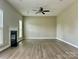 Open living room with modern ceiling fan, fireplace, and neutral paint at 6008 Grassy Knoll Cir, Matthews, NC 28104