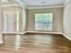 Spacious living room with wood-look flooring and abundant natural light from the large window at 6008 Grassy Knoll Cir, Matthews, NC 28104