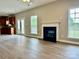 Open-concept living room featuring a fireplace, windows with bright light, and access to kitchen at 6008 Grassy Knoll Cir, Matthews, NC 28104