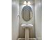 Powder room with a pedestal sink, oval mirror, and light fixture at 6008 Grassy Knoll Cir, Matthews, NC 28104