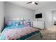 Bright bedroom with a ceiling fan, TV and a well-lit view into the next room at 6359 Mallard View Ln, Charlotte, NC 28269