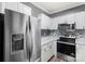 Updated kitchen featuring stainless steel appliances, white cabinets, and mosaic backsplash at 6359 Mallard View Ln, Charlotte, NC 28269
