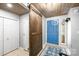 Welcoming entryway featuring blue front door, wood ceiling, and decorative sliding barn door at 6741 Stillmeadow Dr, Charlotte, NC 28277