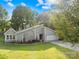 Attractive home featuring a stone accent wall, an attached two-car garage, a bright green lawn, and mature trees at 6741 Stillmeadow Dr, Charlotte, NC 28277