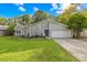Attractive home featuring a stone accent wall, an attached two-car garage, a bright green lawn, and mature trees at 6741 Stillmeadow Dr, Charlotte, NC 28277