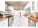 Bright galley kitchen with stainless steel appliances, butcher block countertops, and white cabinetry at 6741 Stillmeadow Dr, Charlotte, NC 28277