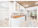 Bright kitchen showcasing white cabinets, butcher block countertops, and view into dining area at 6741 Stillmeadow Dr, Charlotte, NC 28277