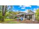 The backyard shows a screened porch, umbrella with table and chairs, a wooded area and a small section of yard at 6741 Stillmeadow Dr, Charlotte, NC 28277