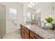 Bright bathroom featuring a granite countertop, wooden cabinetry, and a accessible walk-in shower at 7130 Irongate Dr, Indian Land, SC 29707