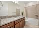 Bathroom featuring a granite countertop, wooden cabinets, bathtub with a shower and neutral tiling at 7130 Irongate Dr, Indian Land, SC 29707