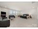 Expansive bedroom with neutral carpet, featuring dual sofas and a bed for optimal lounging and comfort at 7130 Irongate Dr, Indian Land, SC 29707