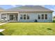 The back of the home features a covered patio with a well manicured backyard and lush green grass at 7130 Irongate Dr, Indian Land, SC 29707