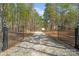 Long gravel driveway through a gated entrance leading to a private estate surrounded by trees at 722 Clegg Farm Dr, York, SC 29745