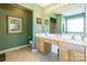 Well-lit bathroom with double sinks, framed mirrors, and neutral tile flooring at 7554 Coastal Way, Huntersville, NC 28078