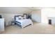 Bright, carpeted bedroom featuring a soft bed, large mirror, and a storage rack at 7554 Coastal Way, Huntersville, NC 28078
