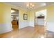Open-concept dining space with hardwood floors, soft lighting, and seamless transition to the kitchen at 7554 Coastal Way, Huntersville, NC 28078