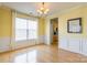 Dining area featuring hardwood floors, wainscoting, and an elegant chandelier with natural light at 7554 Coastal Way, Huntersville, NC 28078