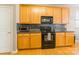 Well-lit kitchen with wood cabinets, stainless appliances and hardwood floors at 7554 Coastal Way, Huntersville, NC 28078