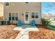 Back patio with tan siding, a white door, two windows, and two blue chairs at 7554 Coastal Way, Huntersville, NC 28078