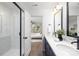 Stylish bathroom with double sink vanity, walk-in shower with glass door, and view into the adjacent bedroom at 8007 Willhill Rd, Mint Hill, NC 28227