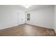 Spacious bedroom with wood-look flooring, natural light, and a closet with double doors at 8007 Willhill Rd, Mint Hill, NC 28227