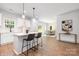 Modern kitchen featuring white cabinets, stainless steel appliances, a breakfast bar, and an open view to the dining area at 8007 Willhill Rd, Mint Hill, NC 28227