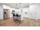 Modern kitchen featuring white cabinets, stainless steel appliances, a breakfast bar, and hardwood floors at 8007 Willhill Rd, Mint Hill, NC 28227