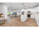Open-concept kitchen with white cabinets, island, stainless steel appliances, and seamless flow to the dining and living areas at 8007 Willhill Rd, Mint Hill, NC 28227