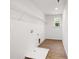 Spacious laundry room with wood floors, white walls, shelving, and window at 8021 Willhill Rd, Mint Hill, NC 28227