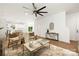 Spacious living room featuring hardwood floors, a modern ceiling fan, and an open floor plan leading to the dining area at 8021 Willhill Rd, Mint Hill, NC 28227