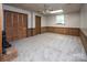 Finished basement with carpet, wood paneling, drop ceiling, and a brick fireplace at 916 Rollingwood Dr, Mount Holly, NC 28120