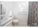 Bathroom featuring a toilet, shower with grey curtain, and window at 916 Rollingwood Dr, Mount Holly, NC 28120