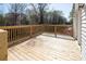 View of a wood deck with wooden railing overlooking a yard with mature trees at 916 Rollingwood Dr, Mount Holly, NC 28120