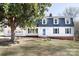 Charming home featuring a blue front door, dormer windows, and manicured lawn at 916 Rollingwood Dr, Mount Holly, NC 28120