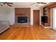 Living room featuring a brick fireplace, hardwood floors, and a wooden door at 916 Rollingwood Dr, Mount Holly, NC 28120