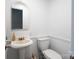 Traditional powder room features pedestal sink, elongated toilet, and arch mirror at 916 Rollingwood Dr, Mount Holly, NC 28120