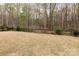 Backyard view featuring a lawn and a dark metal fence with a wooded area backdrop at 938 Moose Trl, Matthews, NC 28104