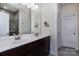 Bathroom featuring double sink vanity, large mirror, and tiled shower with glass door at 938 Moose Trl, Matthews, NC 28104
